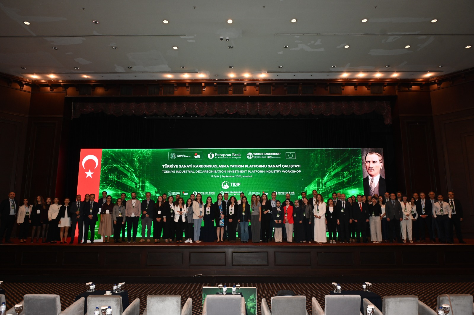 TIDIP Sanayi Çalıştayı sahnesinde Sanayi ve Teknoloji Bakanlığı yetkilileri, uluslararası finans kuruluşlarının temsilcileri ve sanayi liderleri toplu halde duruyor.